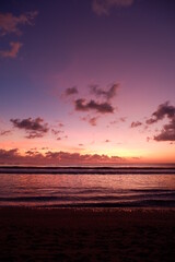 Fototapeta na wymiar A dramatic sunset view on Kuta beach, Bali, with gradations of purple, orange and blue sky