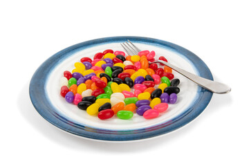 a dinner plate of jelly beans with a fork as if it were a real meal isolated on white