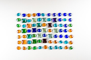 Decorative layout of colored glass on a white background top view