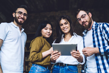 Multiethnic friends in casual wear using tablet together
