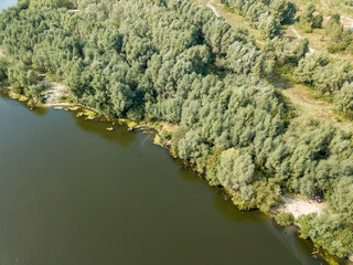 Green banks of a country river. Aerial drone view, sunny summer day.