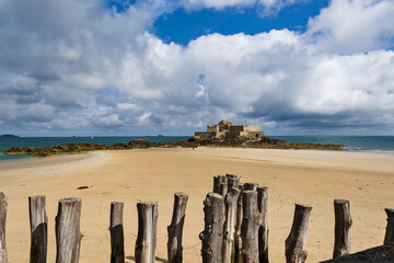 wooden poles on the beach at low tide in Saint Malo, Brittany, France