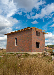 Fototapeta na wymiar Unfinished brick cottage in the village