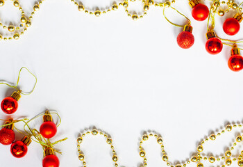 Christmas layout, red Christmas balls, a cone and gold beads on a white background, copy space
