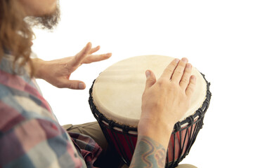 Man plays ethnic drum darbuka percussion, close up musician isolated on white studio background. Male hands tapping djembe, bongo in rhythm. Musical handmade instruments, world culture sound.