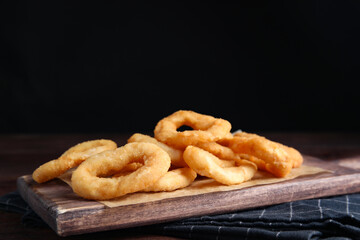 Fried onion rings served on wooden table
