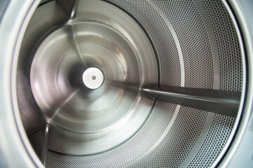 Inner tub of industrial laundry washing machine. Material stainless steel. Shot taken in the factory.