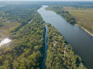 Fototapeta na wymiar Aerial drone view. The bend of a wide river among green meadows. Sunny summer day.