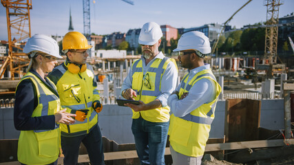 Diverse Team of Specialists Use Tablet Computer on Construction Site. Real Estate Building Project...