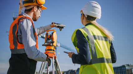 Construction Worker Using Theodolite Surveying Optical Instrument for Measuring Angles in...