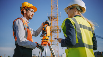 Construction Worker Using Theodolite Surveying Optical Instrument for Measuring Angles in...