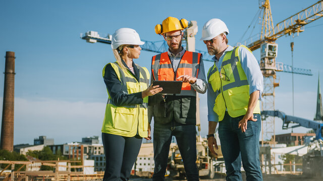 Diverse Team of Specialists Use Tablet Computer on Construction Site. Real Estate Building Project with Civil Engineer, Architect, Business Investor Discussing Planning and Development Details.
