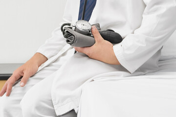 Doctor sitting and holding a blood pressure gauge