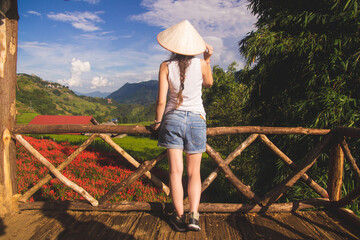 a young European lady dons a traditional Vietnamese hat, immersing herself in the rich cultural...