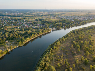 Aerial drone view. The bend of a wide river among green meadows. Sunny summer day.