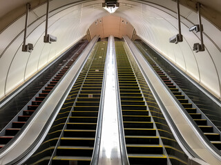 An empty escalator in metro. Transportation of people up and down stairs. Four escalators without people. Mall, elevate