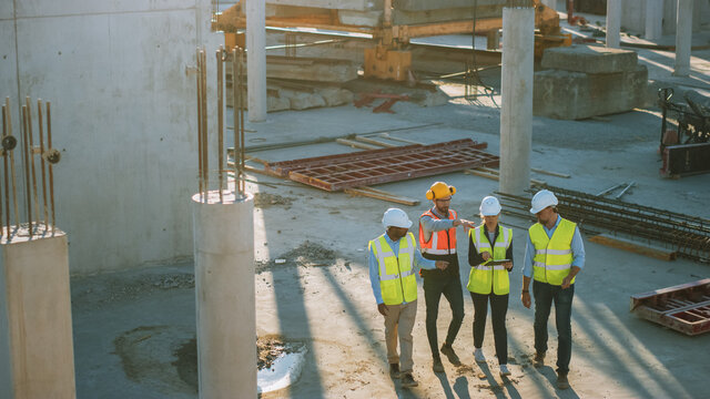 Diverse Team of Specialists Discussing Work on Construction Site. Real Estate Building Project with Senior Civil Engineer, Architect and General Worker Discussing Planning and Development Details.