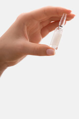 Close-up of a person's hand holding a vial