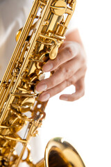 Close up woman playing saxophone isolated on white studio background. Inspired musician, details of...