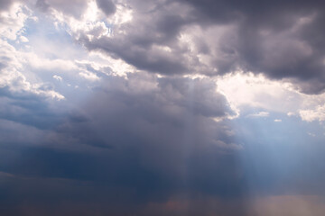 Dramatic clouds. Sun rays come out from behind the clouds.