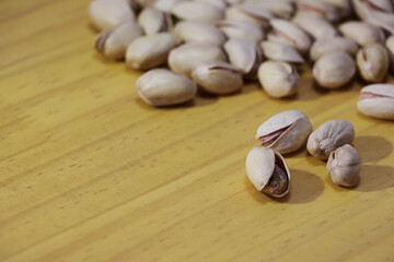 Dry roasted Pistachios on wooden table with copy space