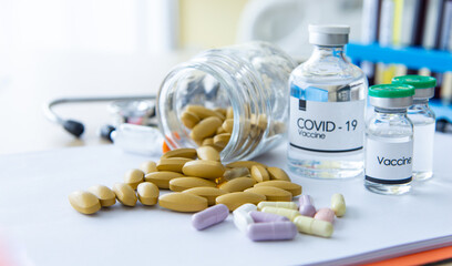 COVID-19 or Coronavirus treatment and preventive concept. Medication tablets for virus infection symptoms. Coronavirus vaccine and positive patient infection sample blood testing in laboratory.