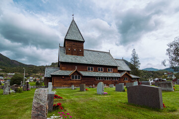 Fototapeta na wymiar Norwegian wooden stave church with its graveyard. Røldal, Norway.