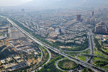 Fototapeta na wymiar View of the city, highway and surrounding houses from the Milad Tower (Borj-e Milad) in Tehran. Milad Tower is the most important monument of Tehran after the Azadi Monument.