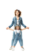 mother and daughter in denim outfits posing and smiling isolated on white