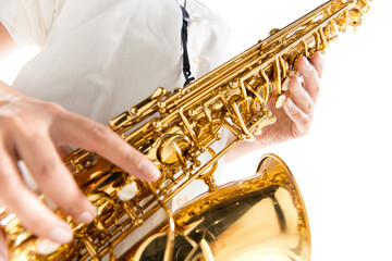 Obraz premium Close up woman playing saxophone isolated on white studio background. Inspired musician, details of art occupation, world classic instrument for jazz and blues. Concept of hobby, creativity.