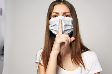 Woman wearing medical mask holds finger near face cropped view 