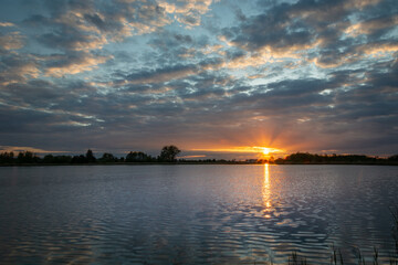 Fototapeta na wymiar Beautiful sunset with clouds over the lake