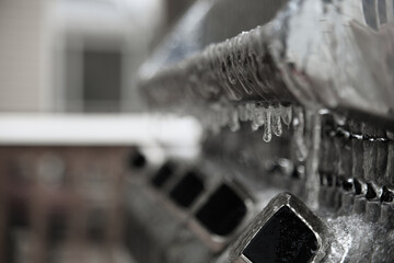 Frozen Steel Grill, covered in ice and icicles, focus on the first grill knob