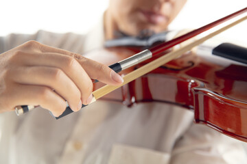Close up woman playing violin isolated on white studio background. Inspired musician, details of...