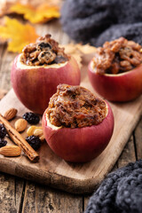Stuffed apples baked with nuts on wooden table.