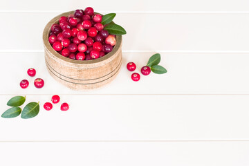 ripe cranberries in a wooden bowl on a white background view above. white background with cranberry close-up. cranberries in a bowl on the table.