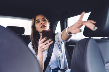 Young woman passenger giving directions to car driver