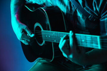 Close up of guitarist hand playing guitar, macro. Concept of advertising, hobby, music, festival,...