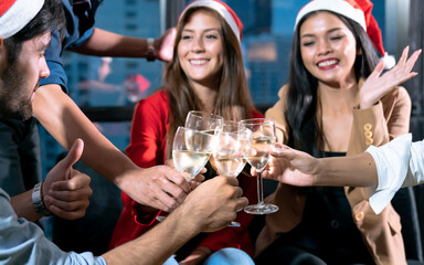 Group of friends having fun with a party, Merry Christmas and Happy New Year, Focus on champagne glasses.