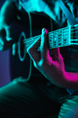 Close up of guitarist hand playing guitar, macro. Concept of advertising, hobby, music, festival,...