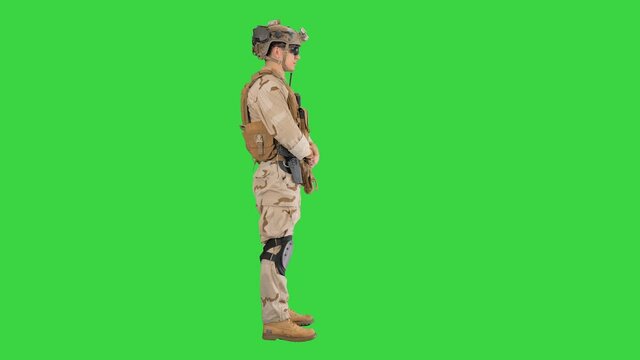Soldier standing waiting and doing nothing on a Green Screen, Chroma Key.