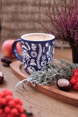cup of coffee and plants on the wooden background, autumn mood, fall