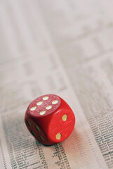 High angle view of a dice on stock market data sheet