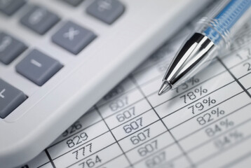 Calculator and a ballpoint pen on financial data