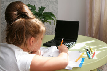 Focused kid self isolation wearing headphones using laptop in cafe, writing notes,student girl...
