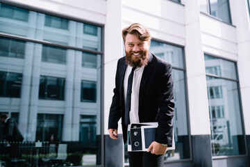 Cheerful businessman walking along street