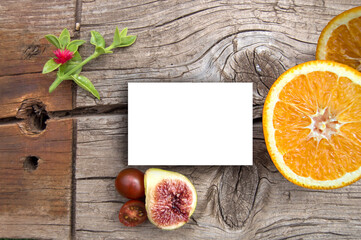 Card on wooden background and fruits presentation