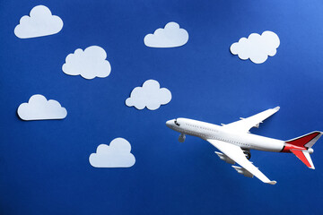 Toy airplane against blue background with clouds
