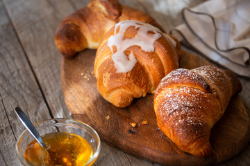 Fresh baked sweet croissants with jam or honey for breakfast