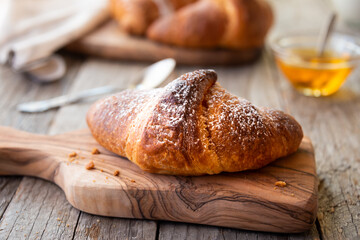 Fresh baked sweet croissants with jam or honey for breakfast